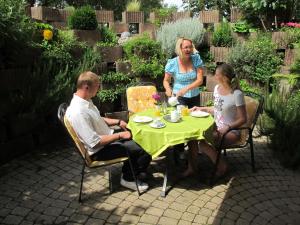 eine Gruppe von Menschen, die in einem Garten am Tisch sitzen in der Unterkunft Gästehaus Wagner in Bad Krozingen