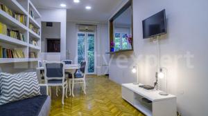 uma sala de estar com uma mesa e uma televisão na parede em Downtown apartment in walk zone with 3 bedrooms and garage em Novi Sad