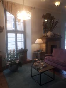 a living room with a purple couch and a table at Hotel Marmułowski in Wejherowo