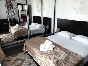 - une chambre avec 2 lits et un grand miroir dans l'établissement Uptown Residence Apartments, à Bucarest