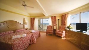 a hotel room with a bed and a television at Hotel Riu Palace Tres Islas in Corralejo