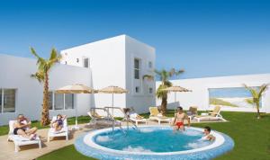 a group of people playing in a pool in a yard at Hotel Riu Palace Tres Islas in Corralejo