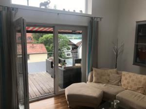 a living room with a couch and a sliding glass door at FeWo mit Seeblick in Bodensdorf