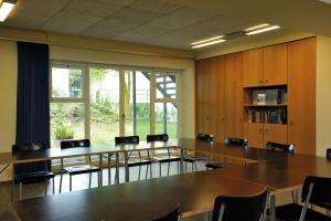 una sala de conferencias con mesas y sillas y una gran ventana en Baden Youth Hostel, en Baden