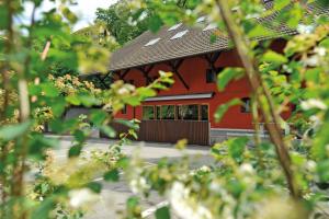 un edificio rojo con techo negro y algunos árboles en Baden Youth Hostel, en Baden