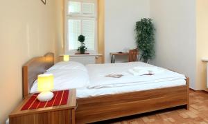 um quarto com uma cama e uma mesa com um candeeiro em Pension Wallis em Plzeň