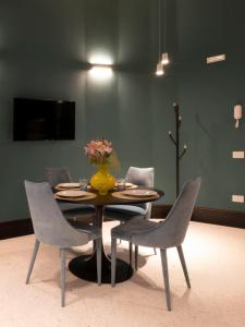 a table with chairs and a vase with flowers on it at Residence Poli Venezia in Venice