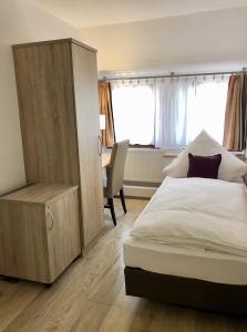 um quarto com uma cama, um armário e uma secretária em A Lotus Hotel em Böblingen