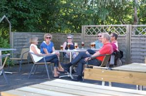 een groep mensen die aan een tafel zitten bij Fjordlyst Camping & Cottages in Aabenraa