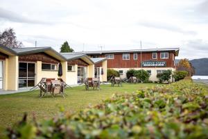 un hotel con sedie e tavoli nel cortile anteriore di Alpine View Motel a Te Anau