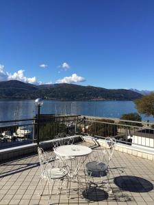 einen Tisch und Stühle auf einem Balkon mit Blick auf das Wasser in der Unterkunft Hotel Europa in Ispra