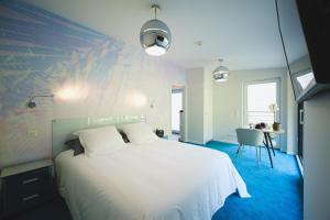 a bedroom with a large white bed and a table at Domaine de la Résidence - Hôtel, Spa & Restaurant in Moulins-lès-Metz