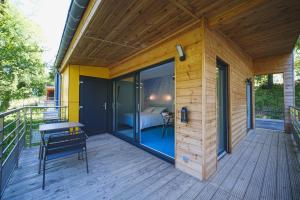 a wooden house with a balcony with a bed on it at Domaine de la Résidence - Hôtel, Spa & Restaurant in Moulins-lès-Metz