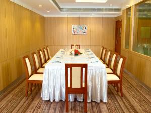 un comedor con una mesa larga con sillas en Hotel Aiswarya, en Kochi