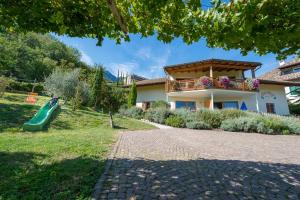 a house with a slide in front of a yard at Weinhof am See in Caldaro