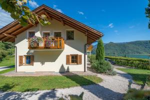 a house with a balcony with flowers on it at Weinhof am See in Caldaro