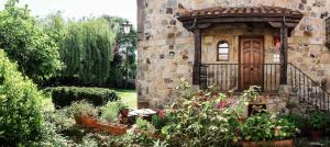 a stone building with a door and some plants at Apartamentos Los Hidalgos in Santillana del Mar