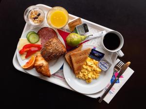 un piatto di prodotti per la colazione e una tazza di caffè di Cabinn Metro a Copenaghen