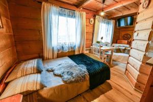 - une chambre avec un lit dans une cabane en rondins dans l'établissement Willa Bachledówka, à Zakopane