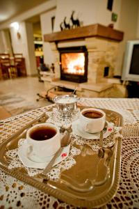 - un plateau avec 2 tasses de café sur une table et une cheminée dans l'établissement Willa Bachledówka, à Zakopane