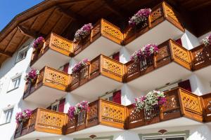 een gebouw met houten balkons en bloemen erop bij Hotel Gries in Canazei