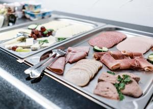 - un plateau de nourriture avec de la viande et d'autres aliments dans l'établissement Hanse Hotel Buxtehude, à Buxtehude