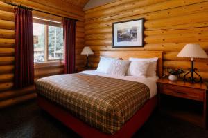 1 dormitorio con 1 cama en una cabaña de madera en Miette Mountain Cabins, en Jasper