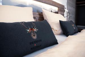 a bed with a black pillow with a deer head on it at Pension Heimat in Ottenhöfen