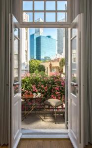 una ventana abierta con vistas al jardín en The Norman Tel Aviv, en Tel Aviv