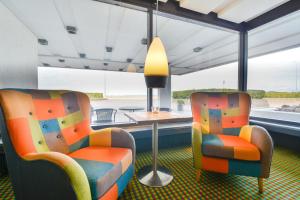 two chairs and a table in a room with a window at Hotel Østersø in Aabenraa