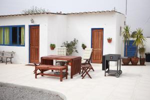 a patio with a table and chairs and a grill at Casal Do Góis Guest House in Atouguia da Baleia