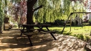 a picnic table and swing under a tree at Apartamentos Los Hidalgos in Santillana del Mar