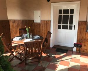 a dining room table with chairs and a white door at Apartman u Karla in Veľký Meder