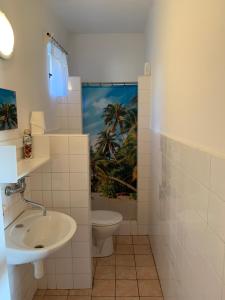 a white bathroom with a toilet and a sink at Apartman u Karla in Veľký Meder