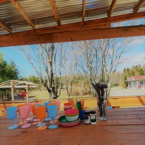 uma mesa com cadeiras coloridas e um vaso no deque em Motel Abricafé em Stoneham