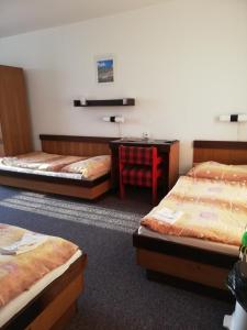 a room with three beds and a desk and a chair at ABC Hotel Nitra in Nitra