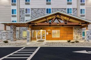 una casa con una veranda in legno con un edificio di WoodSpring Suites Indianapolis Castleton a Indianapolis