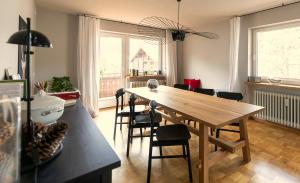 comedor con mesa de madera y sillas en WÄLDER: Quartier Titisee, en Titisee-Neustadt