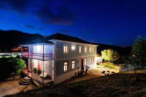 una casa grande por la noche con las luces encendidas en Quinta da Tapada, en Avô