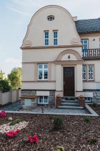 ein großes Haus mit einer Eingangstür und Blumen in der Unterkunft Penzion U Pivovaru in Děčín