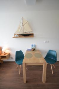 einem Holztisch mit zwei Stühlen und einem Boot an der Wand in der Unterkunft Apartmány Viva Třeboň in Třeboň