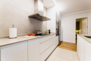 a white kitchen with white cabinets and a sink at ZABALETA SUITE by Sweet Home SS Rentals in Donostia-San Sebastián