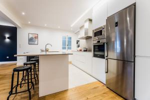 a kitchen with white cabinets and a stainless steel refrigerator at ZABALETA SUITE by Sweet Home SS Rentals in Donostia-San Sebastián