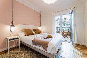 a bedroom with a large bed and a balcony at ZABALETA SUITE by Sweet Home SS Rentals in Donostia-San Sebastián