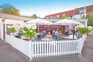 um grupo de pessoas sentadas em mesas fora de um restaurante em Hotel Waldhorn em Böblingen