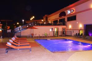 a swimming pool in front of a hotel at night at Lux Hotel & Spa, Trademark Collection by Wyndham in Arlington