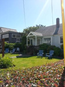 uma casa com cadeiras azuis no quintal em Guesthouse Cannon Beach em Cannon Beach