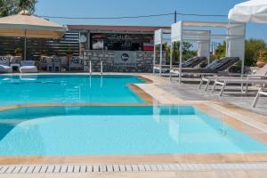 a large swimming pool with chairs and an umbrella at Kastro Maini in Areopolis