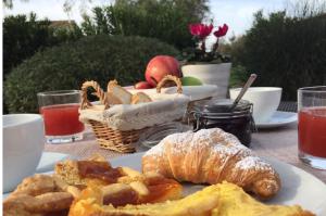 een tafel met een bord ontbijtproducten en een fruitmand bij Agriturismo Le Cascatelle in Saturnia