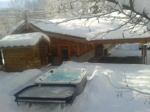 einen Whirlpool im Schnee vor einer Hütte in der Unterkunft Chalet la scie in Samoëns